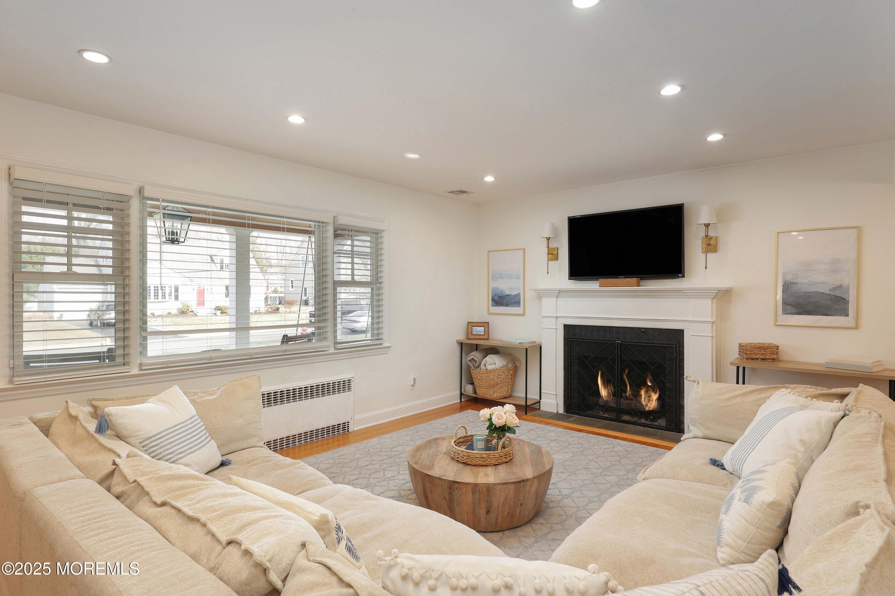 29 SilverWhite Road Little Silver, NJ 07739 - Photo 4 of 38 a living room with furniture a fireplace and a flat screen tv