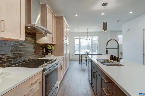 a kitchen with kitchen island stainless steel appliances a sink stove and cabinets