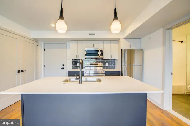 a kitchen with stainless steel appliances a dining table and chairs