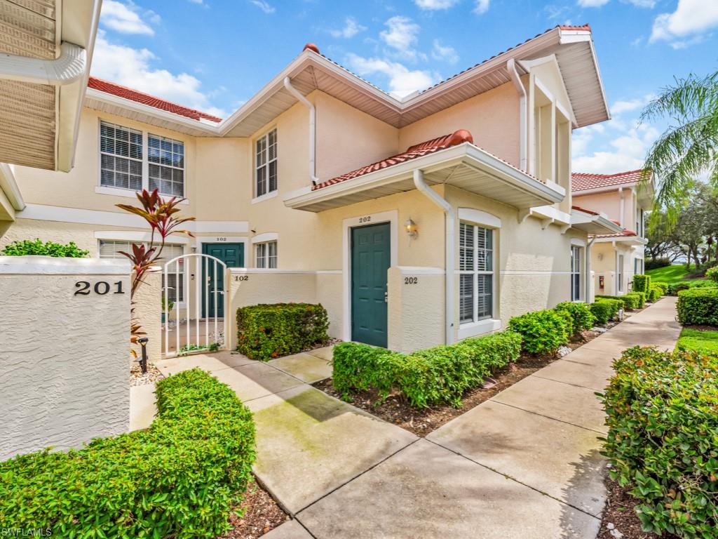 4970 Deerfield Way, Unit F202 Naples, FL 34110 - Photo 1 of 19 a front view of a house with garden
