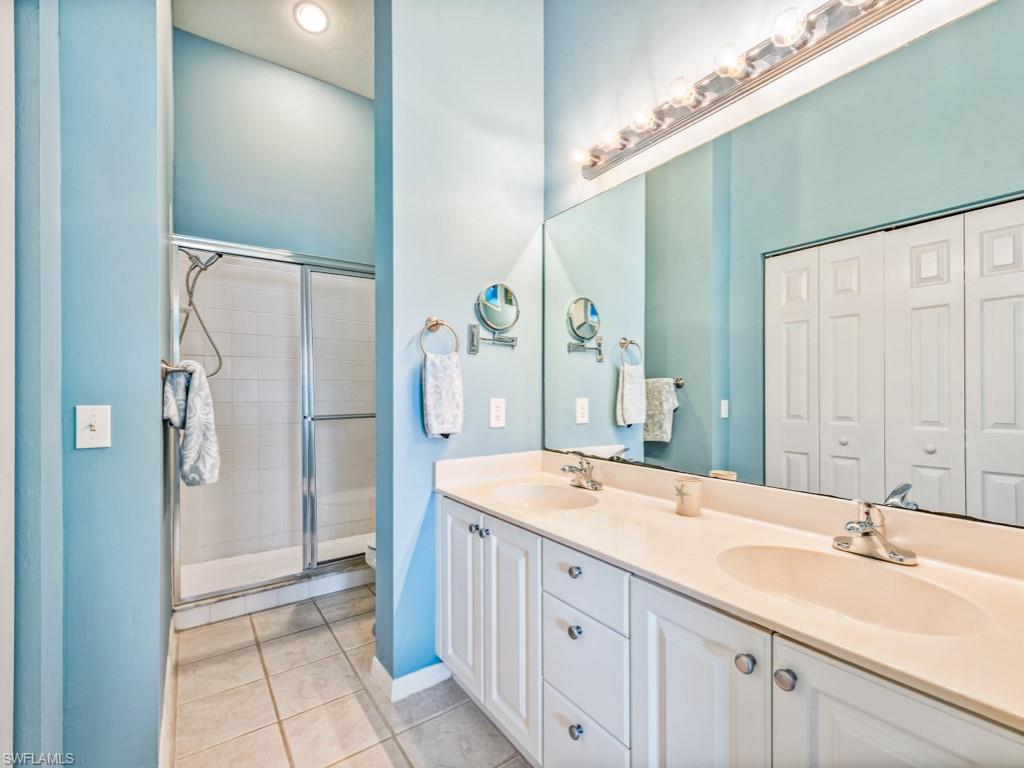 4970 Deerfield Way, Unit F202 Naples, FL 34110 - Photo 12 of 19 a spacious bathroom with a double vanity sink a mirror and a shower