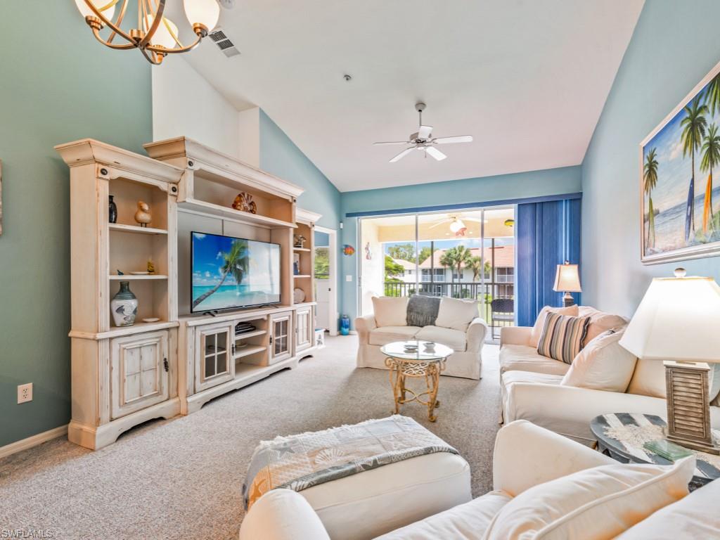 4970 Deerfield Way, Unit F202 Naples, FL 34110 - Photo 2 of 19 a living room with furniture a flat screen tv and a window