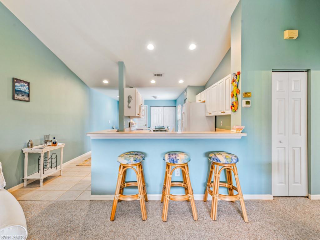 4970 Deerfield Way, Unit F202 Naples, FL 34110 - Photo 6 of 19 a hallway with a dining table and chairs