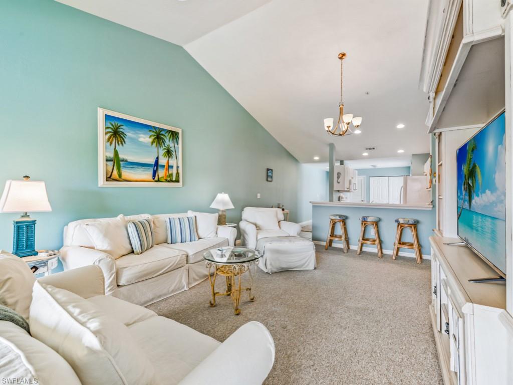 4970 Deerfield Way, Unit F202 Naples, FL 34110 - Photo 8 of 19 a living room with furniture and a chandelier