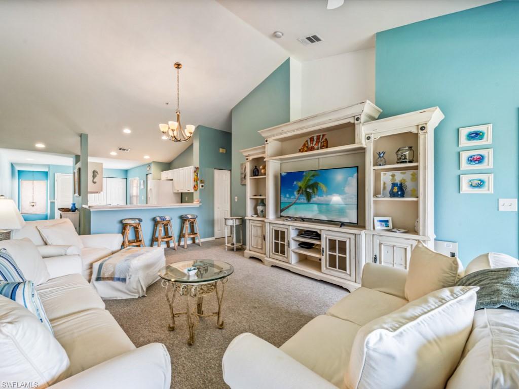 4970 Deerfield Way, Unit F202 Naples, FL 34110 - Photo 9 of 19 a living room with furniture and a flat screen tv