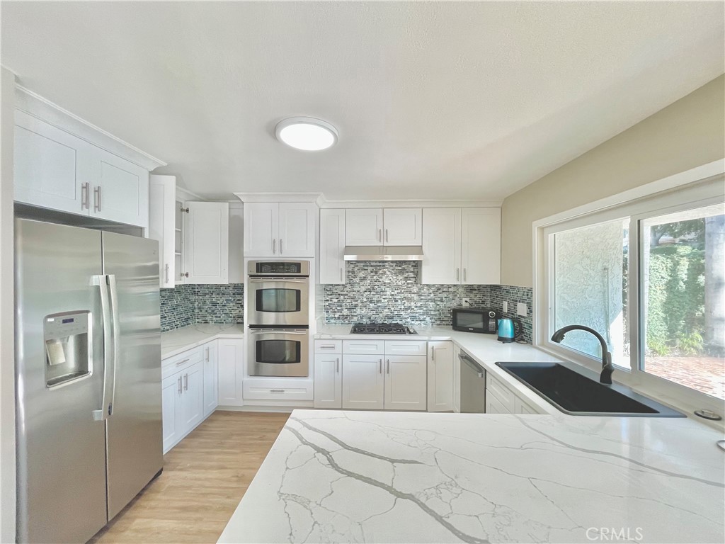 10 Ramada Irvine, CA 92620 - Photo 13 of 22 a kitchen with stainless steel appliances a refrigerator sink and cabinets