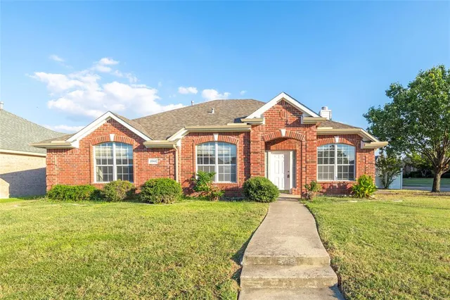 a front view of a house with yard and green space
