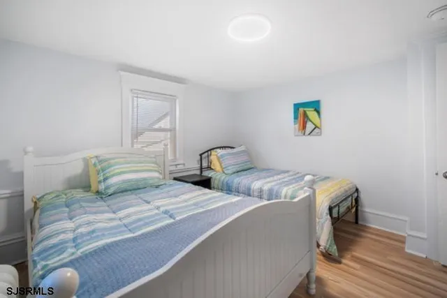 a bedroom with two beds and painting on the wall