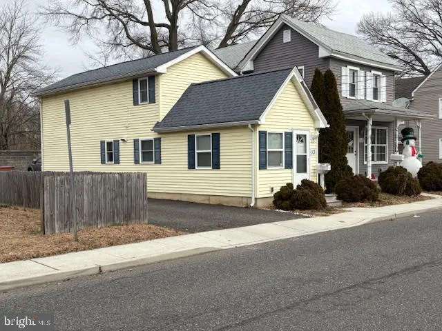 a view of a house with a yard and large tree