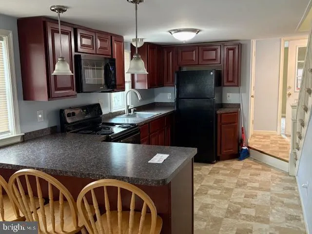 a kitchen with stainless steel appliances granite countertop a sink refrigerator and microwave