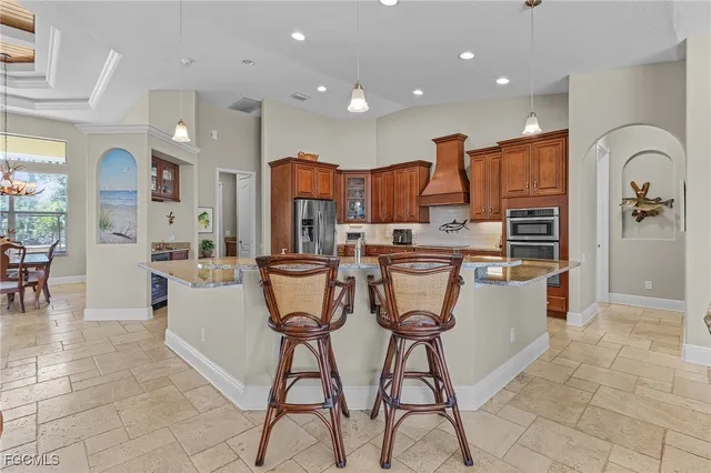 a kitchen with stainless steel appliances kitchen island granite countertop a stove a sink a refrigerator and cabinets