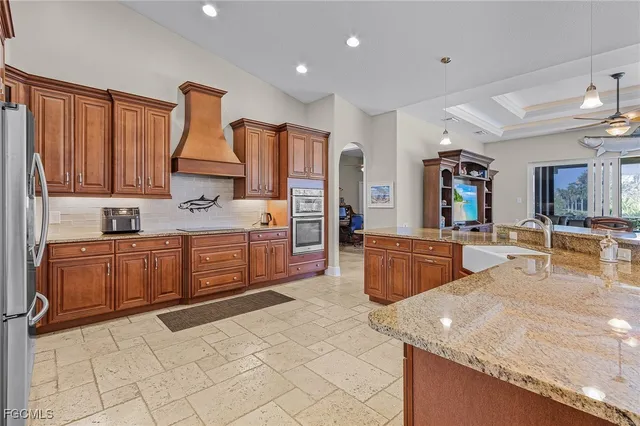 a kitchen with stainless steel appliances granite countertop a stove a sink and a refrigerator