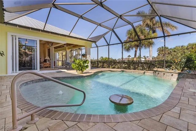 a view of a swimming pool with a dining table and chairs