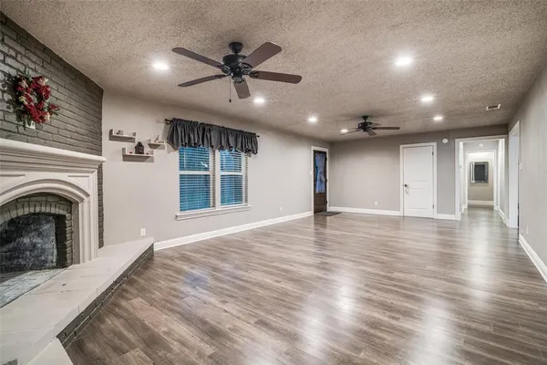 an empty room with wooden floors and fireplace