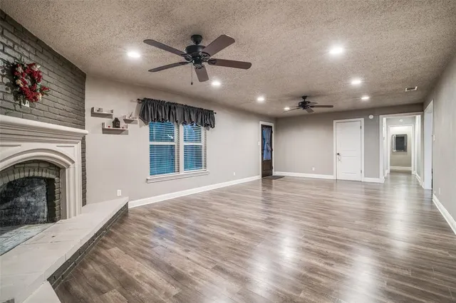 an empty room with wooden floors and fireplace