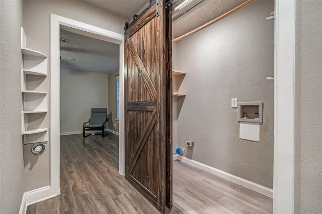 a view of a hallway with a room and wooden floor