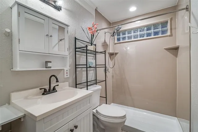 a bathroom with a sink a toilet and shower