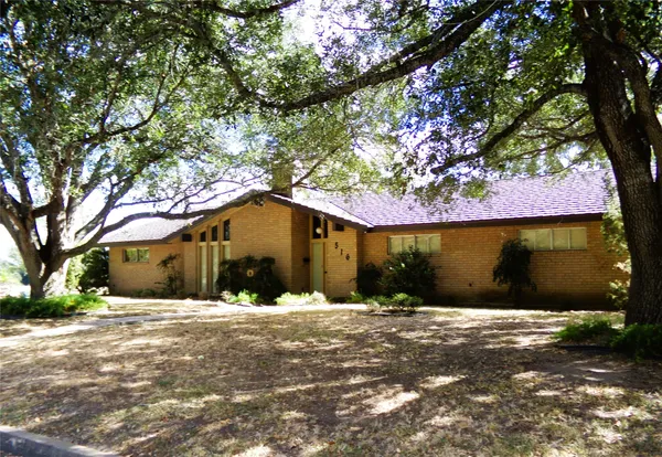 a front view of house with yard covered in snow