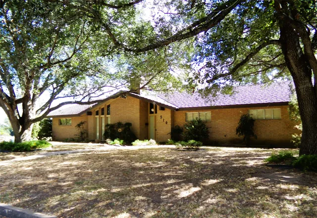 a front view of house with yard covered in snow