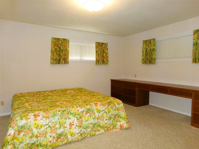 a bedroom with a bed and a wall painting