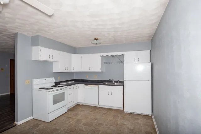 a kitchen with white cabinets and white appliances