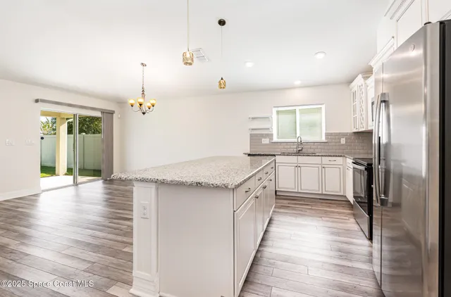 a kitchen with stainless steel appliances granite countertop a sink a stove and a refrigerator