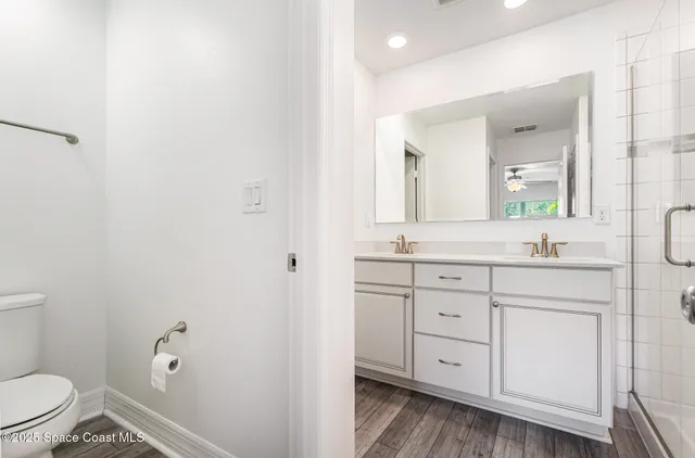 a bathroom with a granite countertop sink toilet and mirror