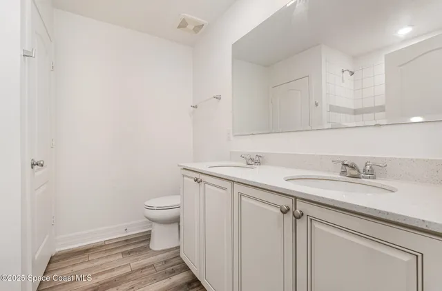 a bathroom with a granite countertop sink and a toilet