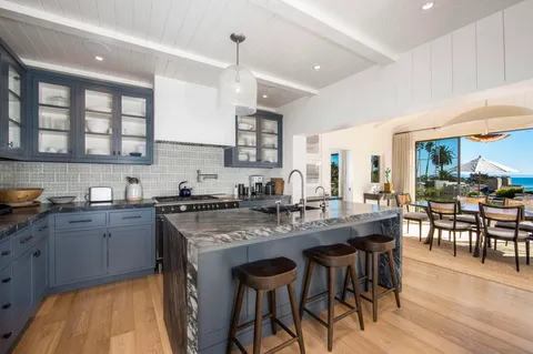 a kitchen with stainless steel appliances granite countertop table chairs sink and cabinets