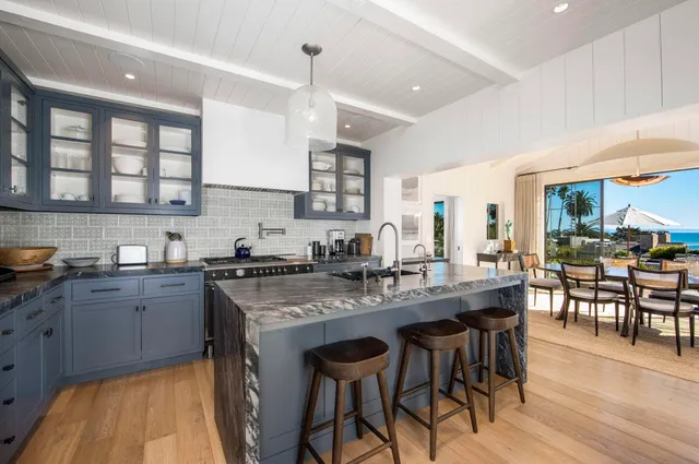 a kitchen with stainless steel appliances granite countertop table chairs sink and cabinets