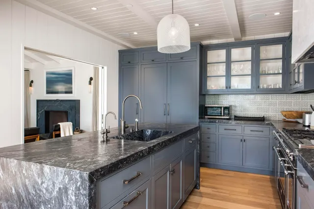 a kitchen with stainless steel appliances granite countertop a sink chairs and cabinets