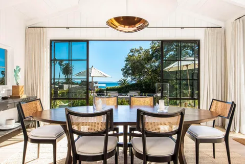 a dining room with furniture and a floor to ceiling window
