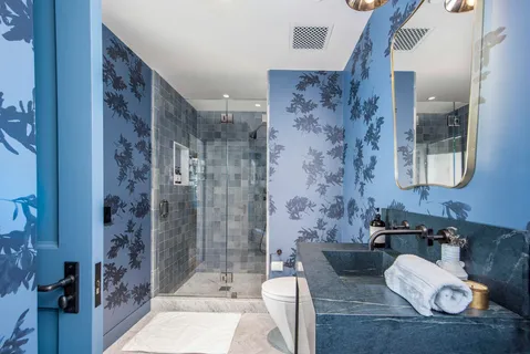 a bathroom with a granite countertop sink a toilet and shower