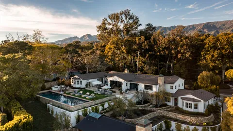 an aerial view of a house with a mountain