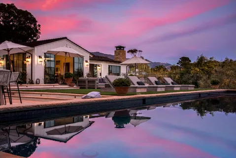 a front view of a house with swimming pool and a sitting area