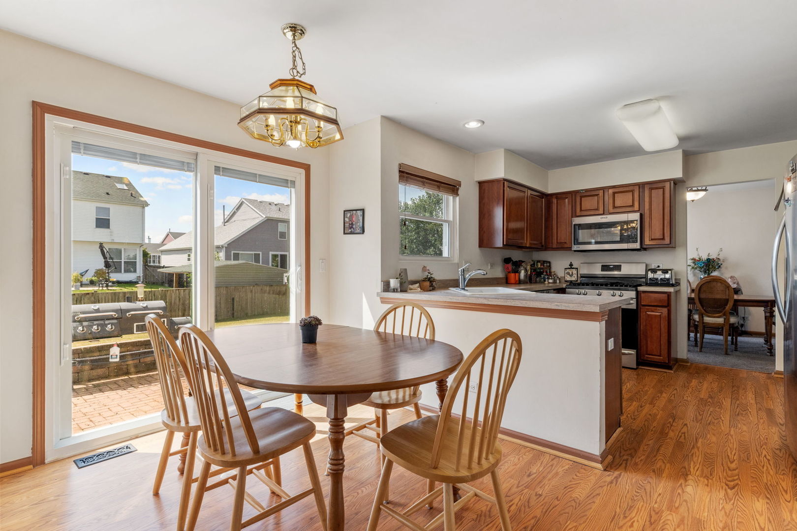 601 Greystone Lane Bolingbrook, IL 60440 - Photo 8 of 20 a kitchen with stainless steel appliances granite countertop a stove a refrigerator a kitchen island a dining table and chairs with wooden floor