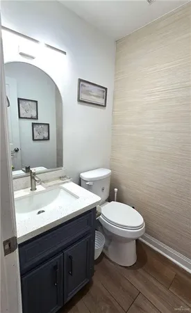 a bathroom with a sink mirror vanity and toilet