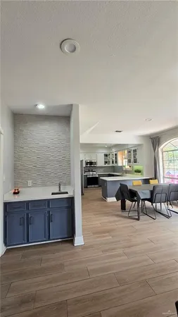 a living room with stainless steel appliances kitchen island granite countertop a sink and cabinets