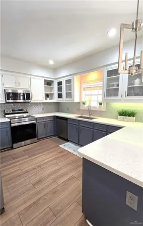 a large kitchen with granite countertop a stove top oven and sink