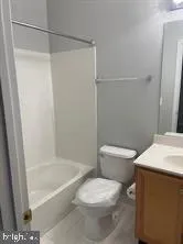 a white toilet sitting next to a bath tub