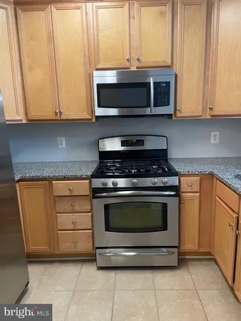 a kitchen with stainless steel appliances granite countertop a stove microwave and cabinets