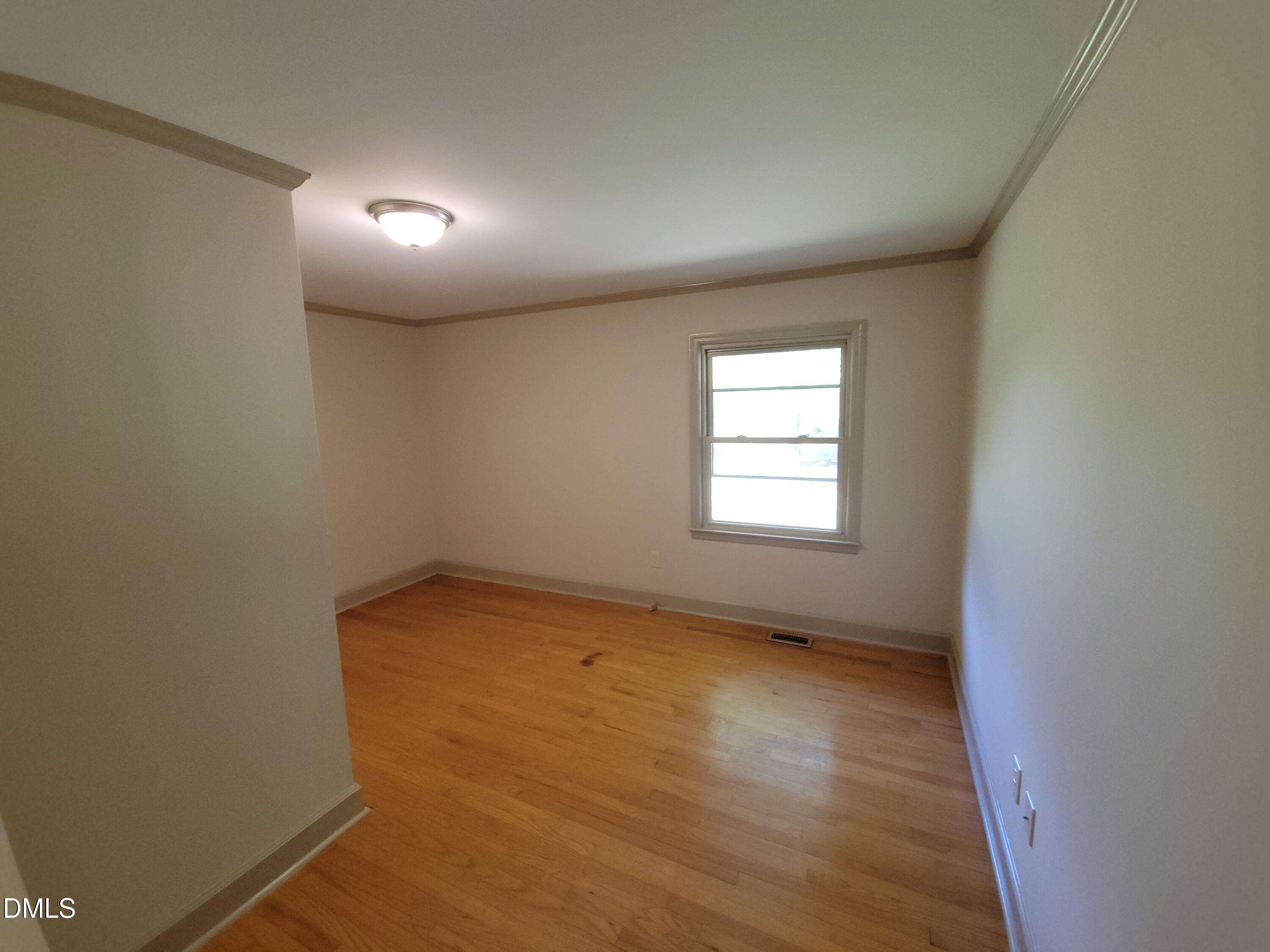 7000 Holly Springs Road Raleigh, NC 27606 - Photo 13 of 24 an empty room with wooden floor and windows