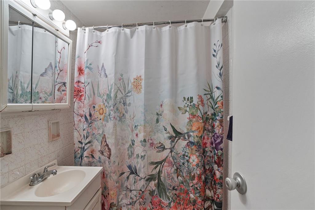 4625 Fifth Avenue, Unit 116 Pittsburgh, PA 15213 - Photo 15 of 25 a bathroom with a shower curtain and a sink