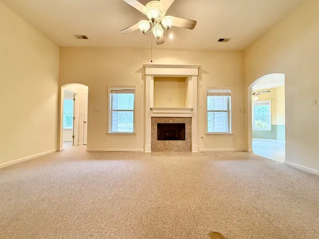a view of an empty room with a fireplace and a window