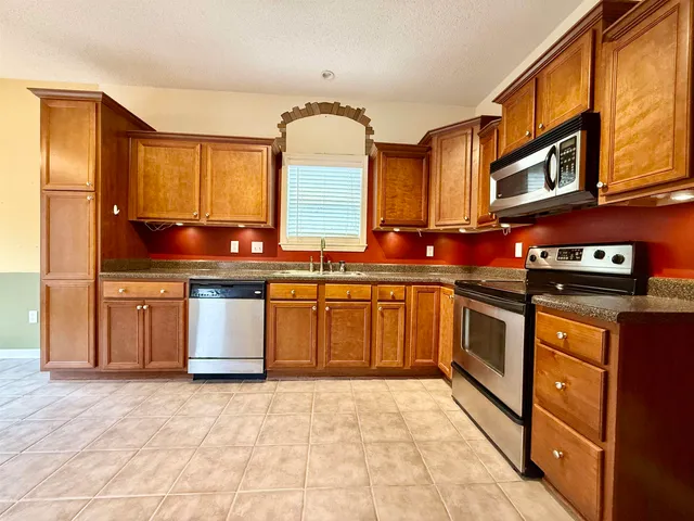 a kitchen with stainless steel appliances granite countertop a stove sink and cabinets