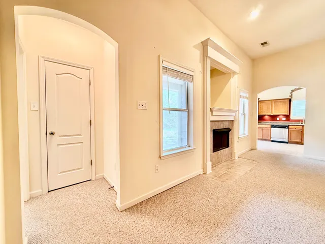a view of a livingroom with furniture fire place and a refrigerator