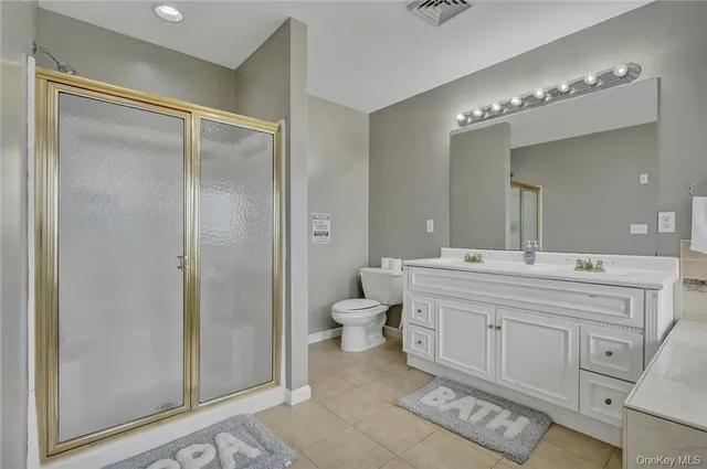 a spacious bathroom with a double vanity sink mirror and toilet
