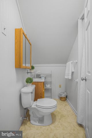a white toilet sitting next to a bathroom sink and a mirror