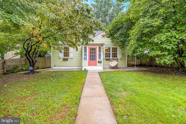 a front view of a house with a yard and green space