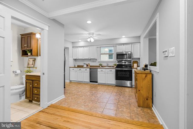 a kitchen with stainless steel appliances granite countertop a stove top oven a sink and a refrigerator